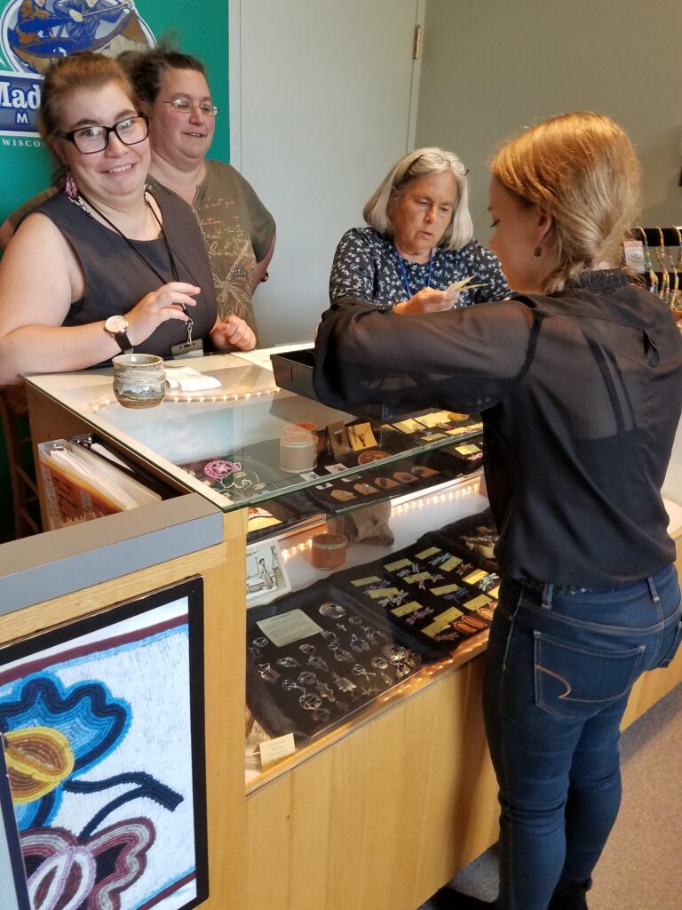 Several staff members help a customer at the front desk during their employment
